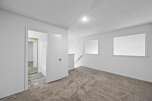 empty room featuring carpet floors and a textured ceiling