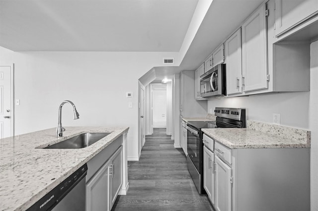 kitchen with light stone counters, sink, stainless steel appliances, and dark wood-type flooring