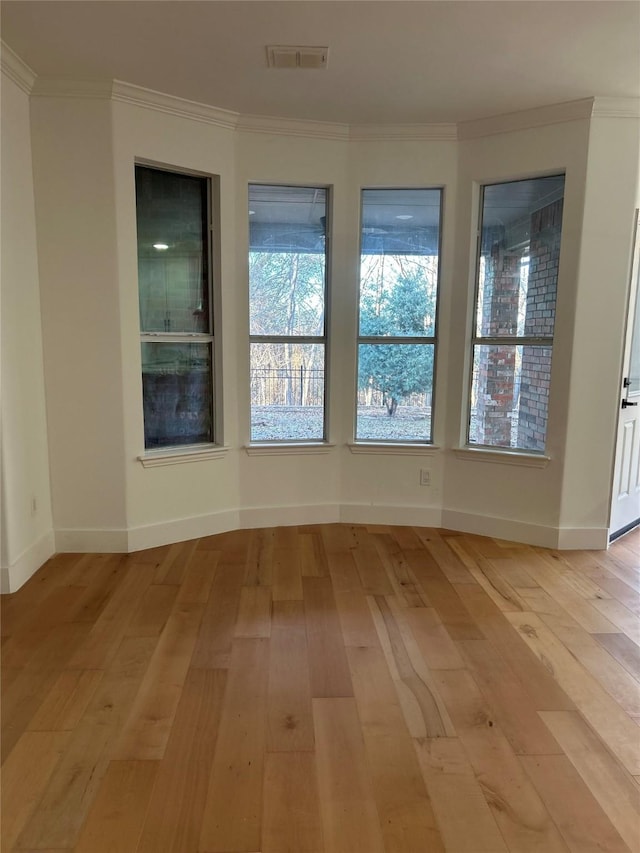 empty room featuring light hardwood / wood-style floors and crown molding