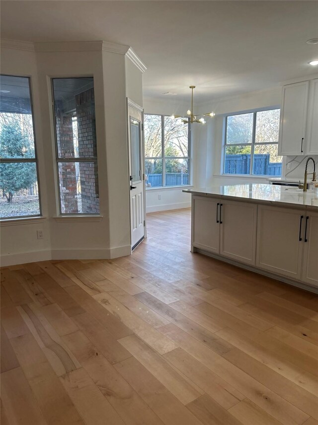 kitchen featuring a notable chandelier, sink, and white cabinetry