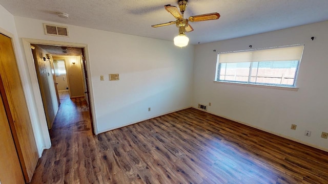 unfurnished room featuring a textured ceiling, dark wood-type flooring, and ceiling fan