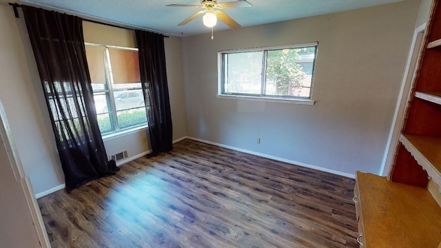 unfurnished room featuring ceiling fan and dark wood-type flooring