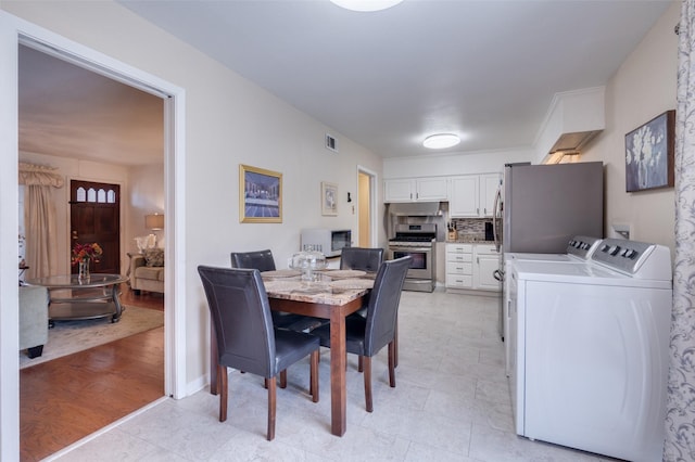 dining room featuring light hardwood / wood-style floors and separate washer and dryer