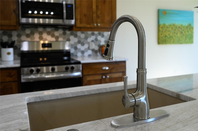 kitchen with stainless steel appliances, brown cabinets, light countertops, and decorative backsplash