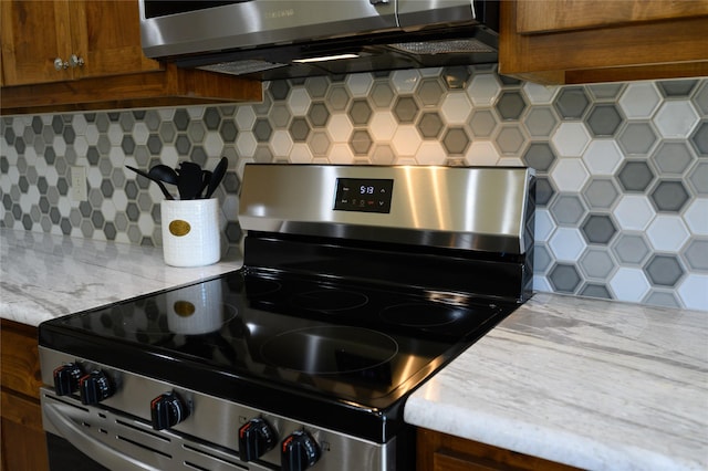 kitchen featuring appliances with stainless steel finishes, light countertops, brown cabinetry, and tasteful backsplash