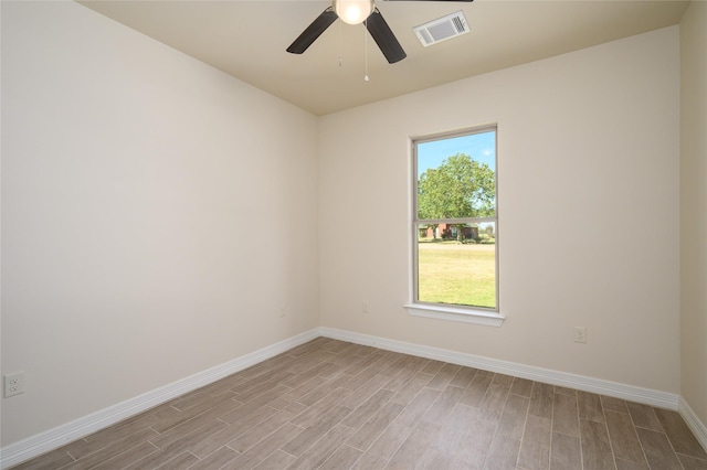 unfurnished room featuring a healthy amount of sunlight, light wood finished floors, baseboards, and visible vents