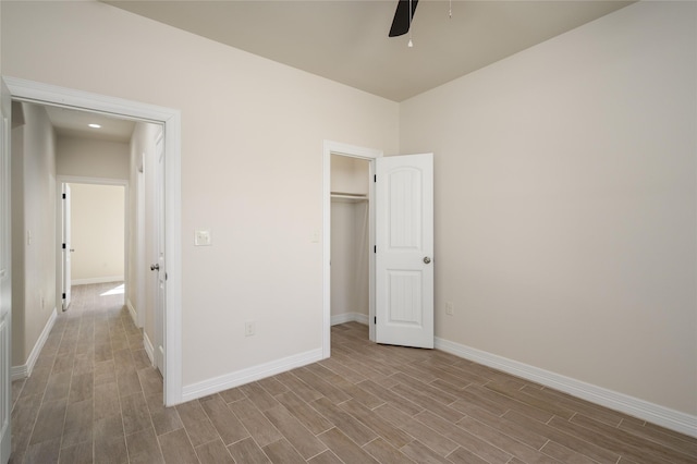 unfurnished bedroom with a ceiling fan, baseboards, and wood finished floors