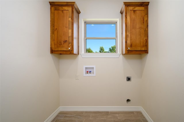 laundry area with hookup for a washing machine, cabinet space, baseboards, and electric dryer hookup