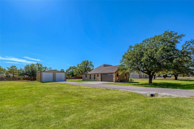 view of yard featuring a garage, an outdoor structure, and fence