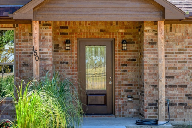 doorway to property featuring brick siding