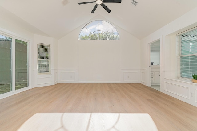 empty room with ceiling fan, vaulted ceiling, and light wood-type flooring