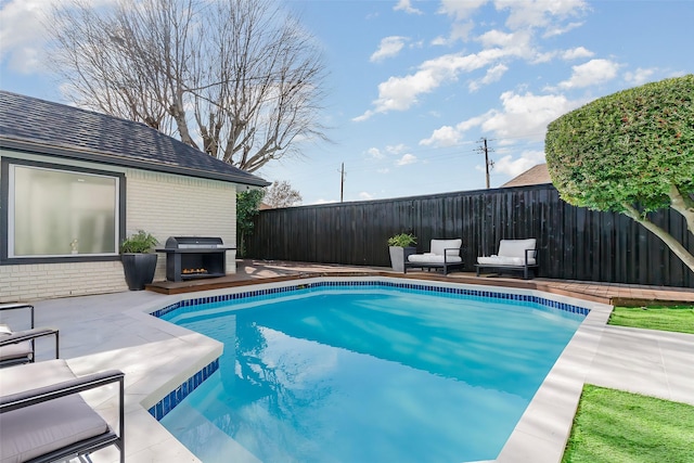 view of pool featuring a grill and a patio area