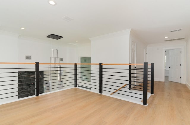 empty room featuring ornamental molding and light hardwood / wood-style flooring