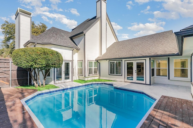 view of swimming pool with french doors and a deck