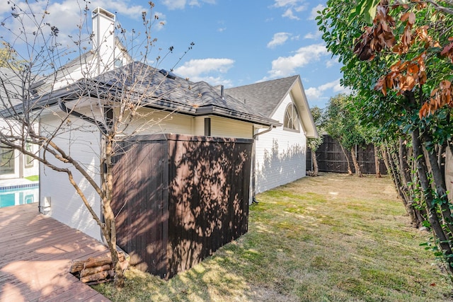 view of side of property with a deck and a lawn