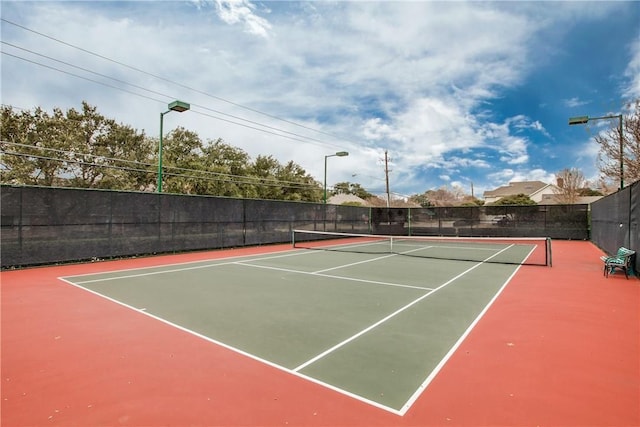 view of tennis court featuring basketball hoop