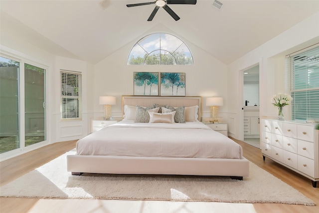 bedroom with ceiling fan, ensuite bathroom, light hardwood / wood-style floors, and lofted ceiling