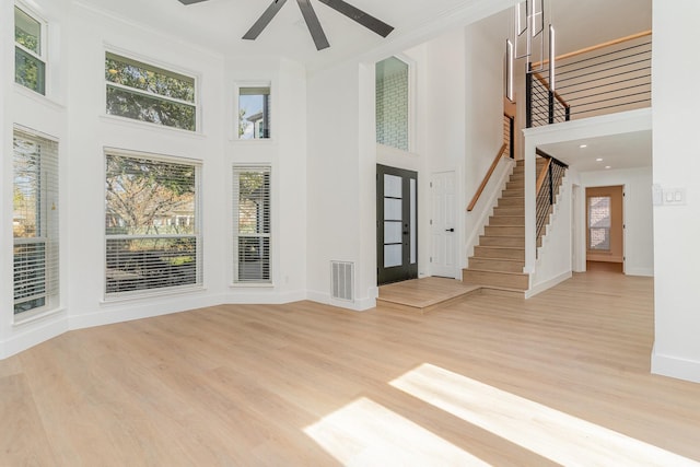 unfurnished living room with a wealth of natural light, ceiling fan, and light hardwood / wood-style flooring