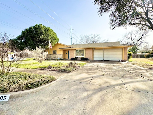 ranch-style home with a garage, driveway, brick siding, and fence