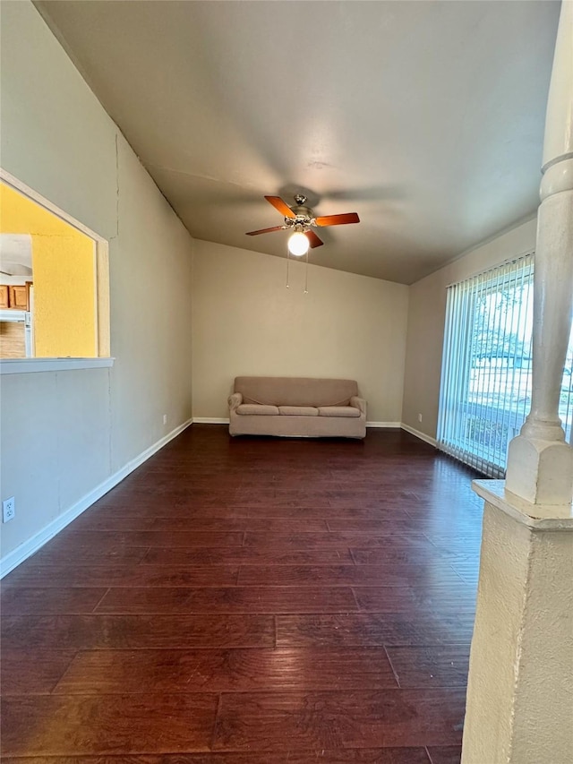 unfurnished living room with a ceiling fan, dark wood finished floors, and baseboards