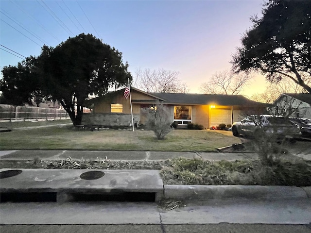 view of front of house featuring a garage and a lawn