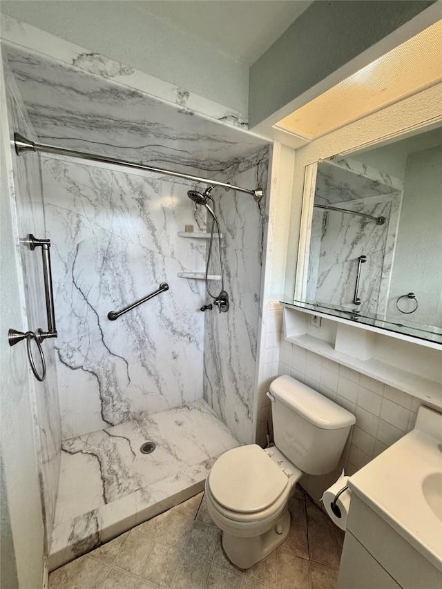 bathroom featuring a marble finish shower, vanity, and toilet