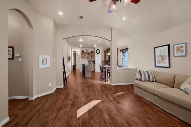 living room featuring vaulted ceiling, dark wood-type flooring, sink, and ceiling fan