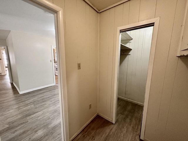 hall featuring dark hardwood / wood-style floors and wooden walls