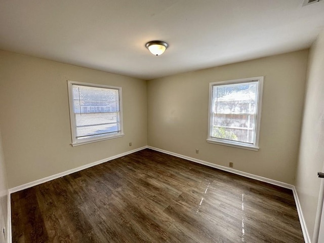 unfurnished room with dark wood-type flooring