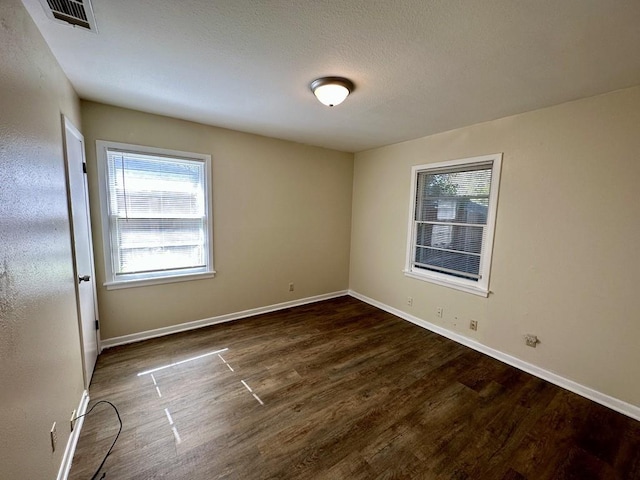 empty room with dark hardwood / wood-style flooring