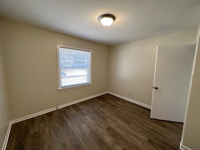 unfurnished room with dark hardwood / wood-style floors