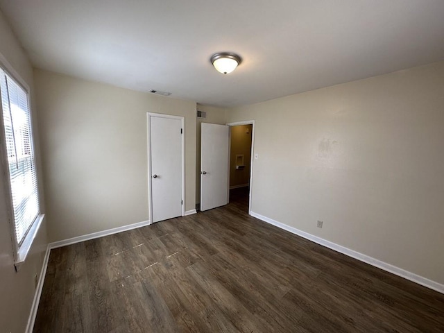 unfurnished room with dark wood-type flooring