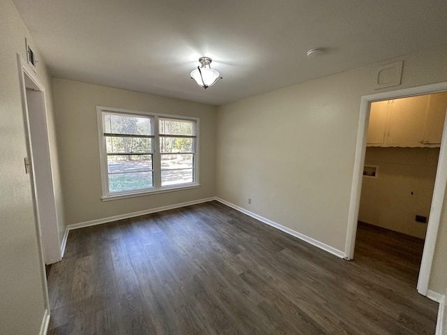 unfurnished bedroom with a walk in closet, a closet, and dark hardwood / wood-style flooring