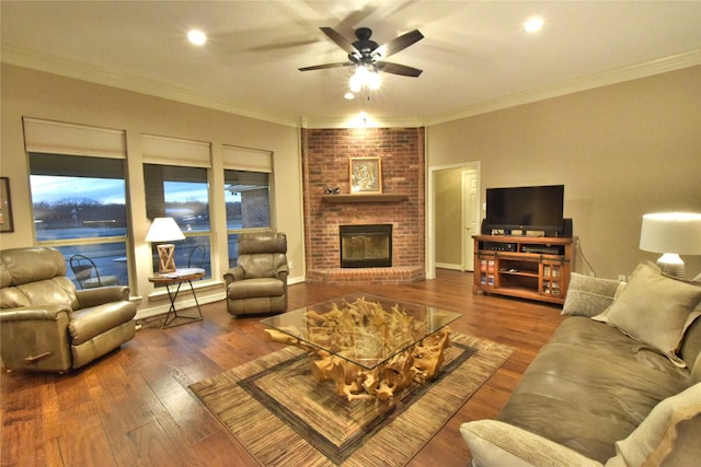 living room with ceiling fan, a fireplace, crown molding, and hardwood / wood-style floors