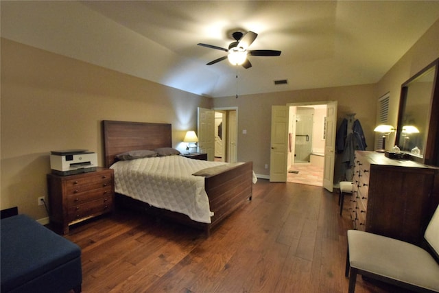 bedroom with vaulted ceiling, ceiling fan, ensuite bathroom, and dark hardwood / wood-style flooring