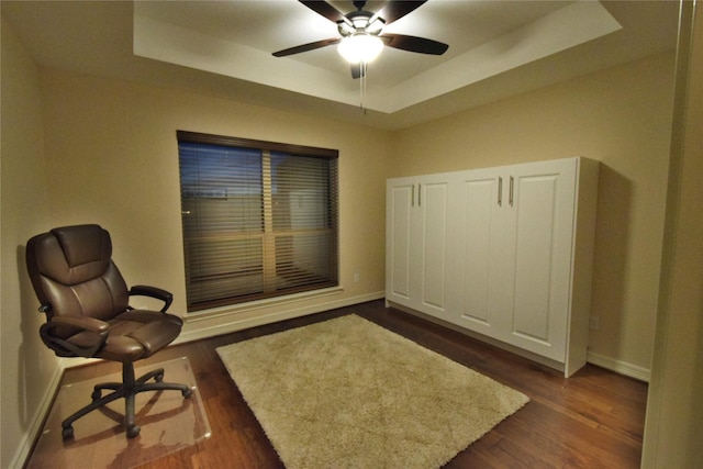 office featuring ceiling fan, dark hardwood / wood-style flooring, and a tray ceiling