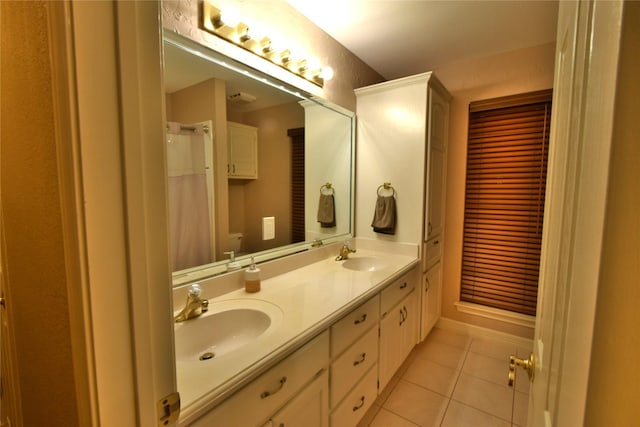 bathroom featuring toilet, vanity, and tile patterned floors