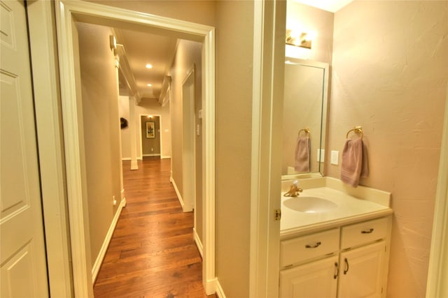 bathroom with crown molding, hardwood / wood-style flooring, and vanity