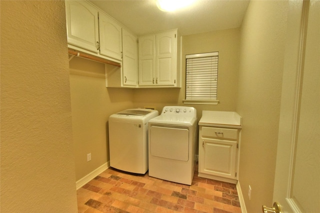 laundry area featuring separate washer and dryer and cabinets