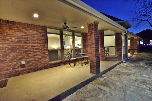 patio at twilight featuring ceiling fan