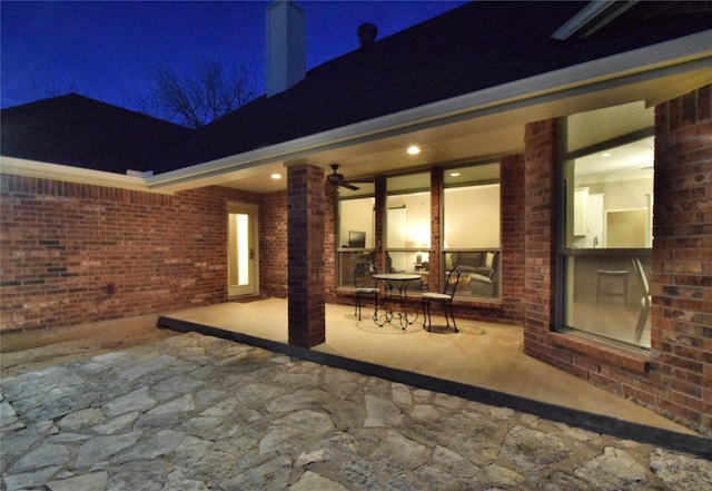 patio at twilight featuring ceiling fan