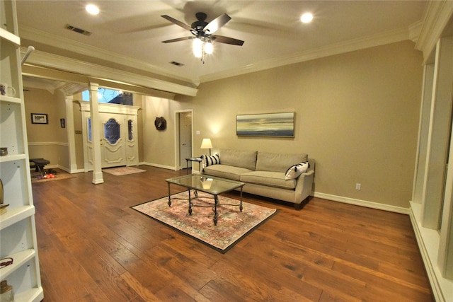 living room with ceiling fan, dark hardwood / wood-style floors, ornamental molding, and ornate columns