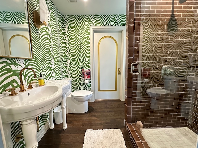 bathroom with toilet, wood-type flooring, and walk in shower