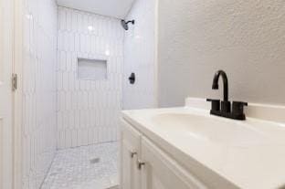 bathroom featuring vanity and tiled shower