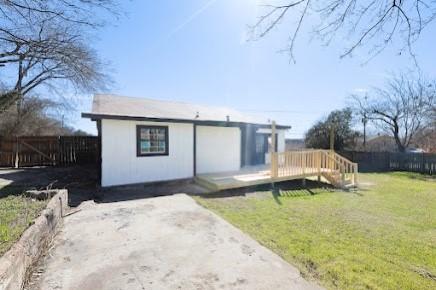 rear view of property featuring a lawn and a deck