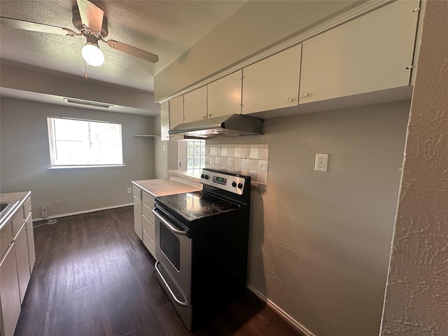 626 Sunset Dr, Garland, TX 75040 - kitchen featuring stainless steel range with electric cooktop, a ceiling fan, under cabinet range hood, dark wood-style flooring, and decorative backsplash