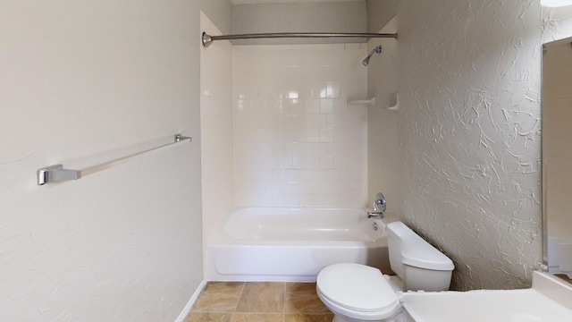 bathroom featuring tiled shower / bath combo and toilet