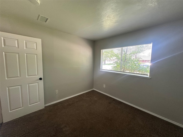 626 Sunset Dr, Garland, TX 75040 - spare room with dark carpet, baseboards, and visible vents