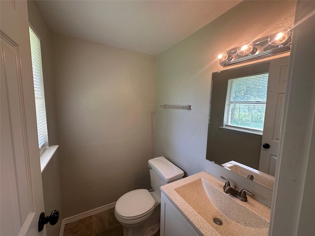 626 Sunset Dr, Garland, TX 75040 - bathroom featuring toilet, vanity, and baseboards