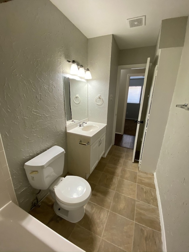 bathroom featuring vanity, tile patterned flooring, and toilet